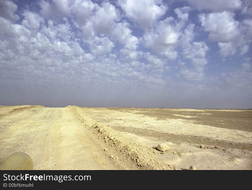 Running on a Sahara yellow track under blue and cloudy sky. Running on a Sahara yellow track under blue and cloudy sky