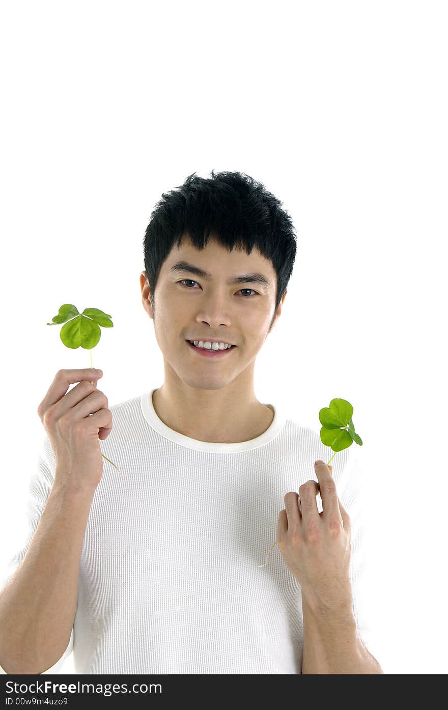 Young man holding up a green leaf by posing