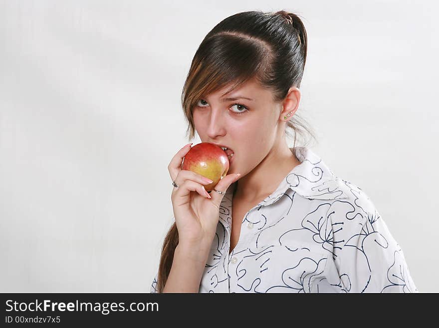 The girl cares about health eats a red apple