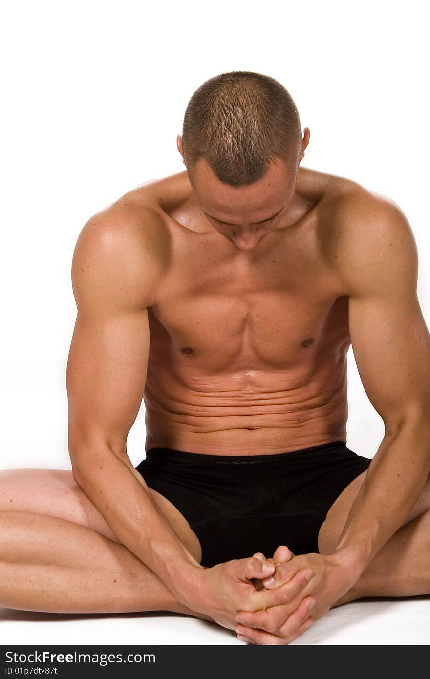 Young sportsman stretching on the white background