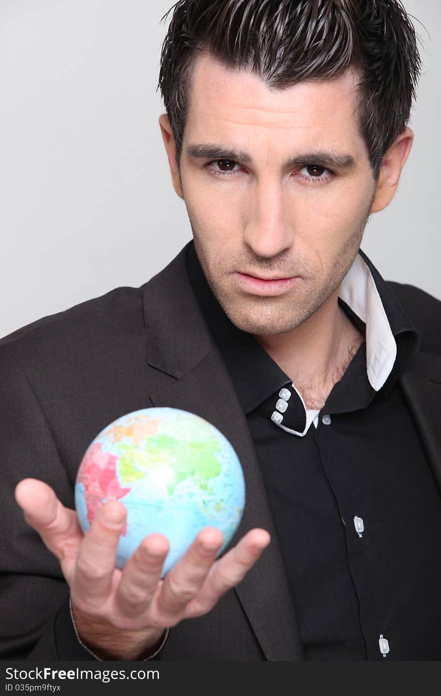 Portrait of a man in suit holding a globe