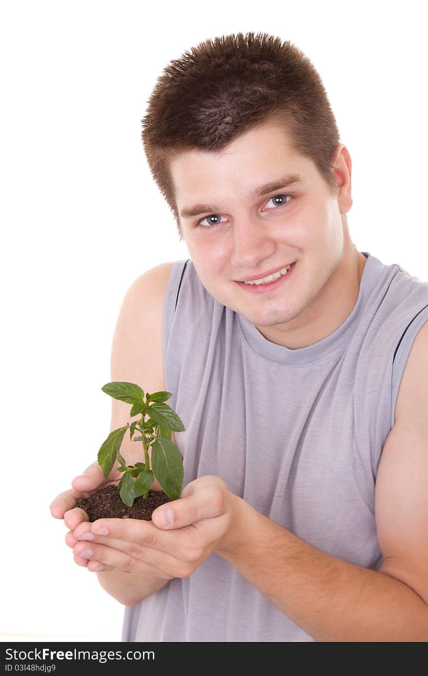 A young man holding a plant in hands