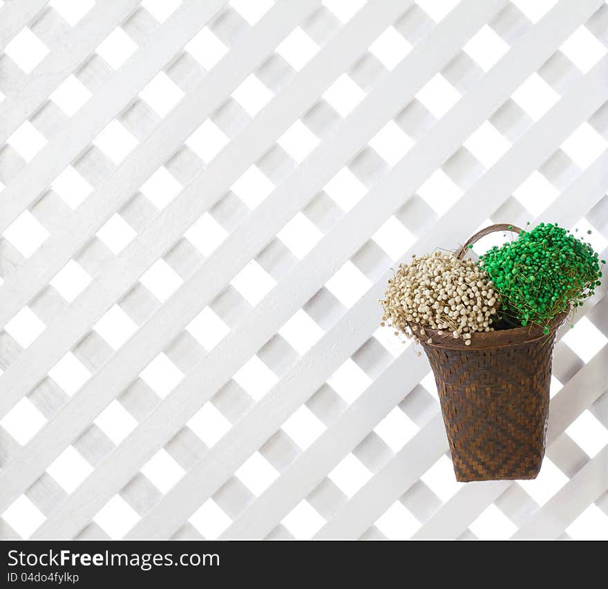 Wooden lattice background with dried flowers in bamboo basket. Wooden lattice background with dried flowers in bamboo basket