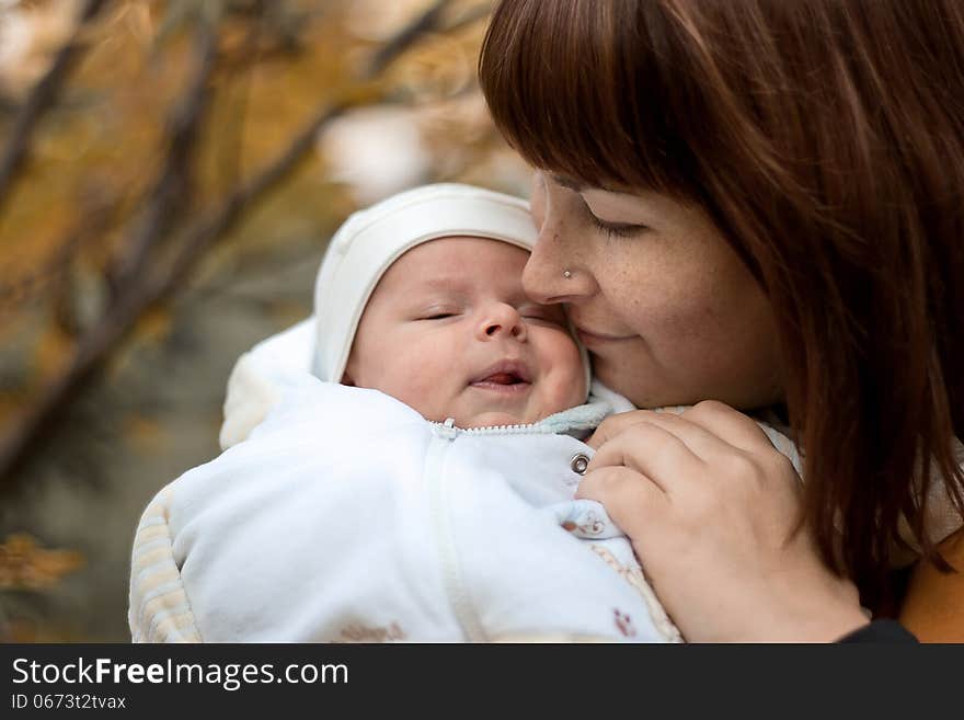 Newborn on the mother s hands in the park in autumn