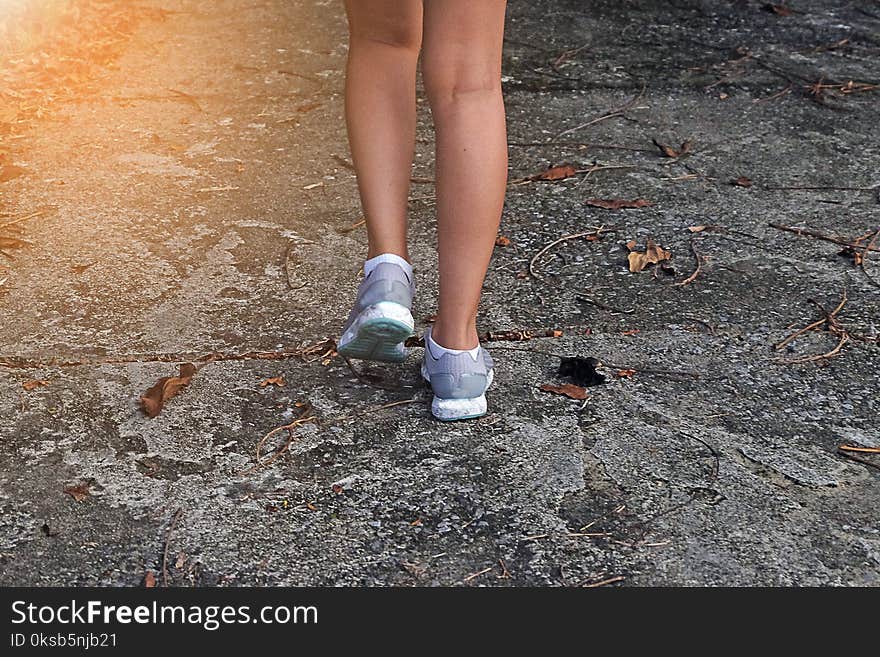 Young Woman Jogging Close-up on the road