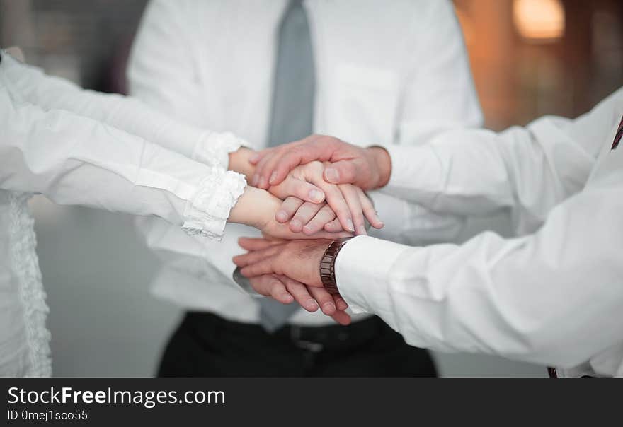 Business team shows its unity clasped their hands together.the concept of teamwork. Business team shows its unity clasped their hands together.the concept of teamwork