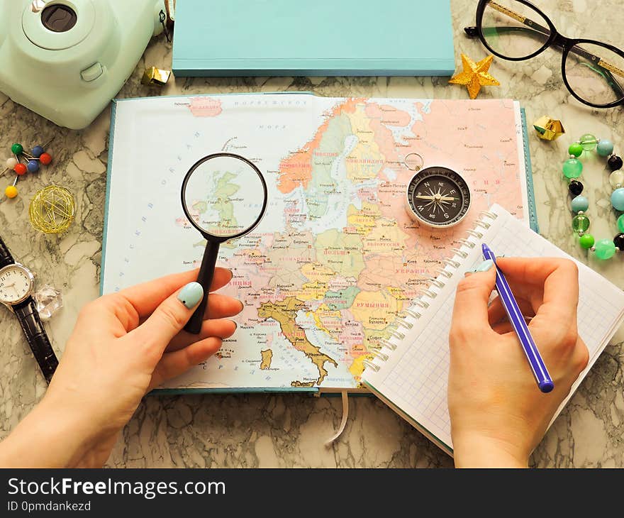 Top View of a map and items. Planning a trip or adventure. Travel planning dreams. Map of the world. Travel, tourism and vacation concept background. Stylish notebook, map and magnifier. Flat lay.