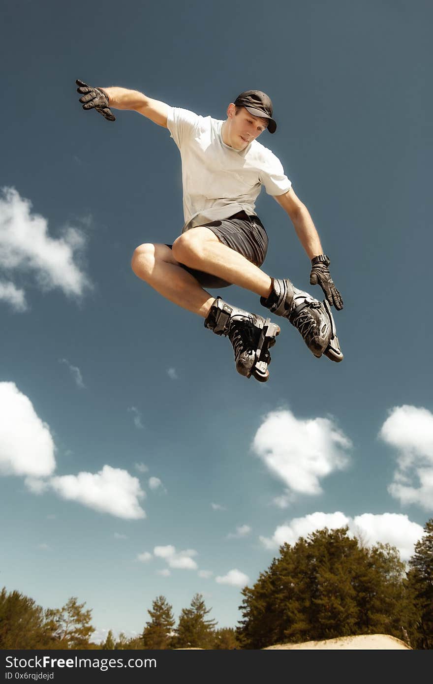 Athlete inline skating practices jumping tricks on an asphalt track