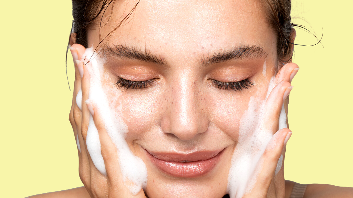 Woman going through the cleansing stage of her skincare routine.