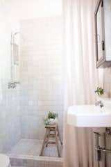 In the guest bath, white zellige tiles from Clé line the walls and floors and boast a myriad of undertones, from gray to cream to pink, which sync with the rest of the house.