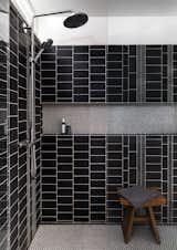 A custom mix of graphite tiles from Ann Sacks line the walls of the master bath. The floors are white penny rounds from American Universal Corporation.