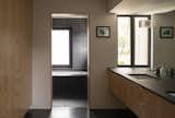 The clean cabinetry and moody tiling yield a relaxing upstairs master bath. 