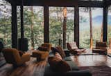 Living Room, Sofa, Medium Hardwood Floor, Wood Burning Fireplace, Chair, and Ceiling Lighting The "criss-cross" floor plan and high ceilings make the most of the small, mountainous site making the home feel more expansive than its 1200 sq ft layout would indicate.   Photo 11 of 28 in Hidden Lake Lookout by Jack Baldwin