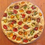 A picture of Foccacia with cherry tomatoes, rosemary and pomegranate molasses.