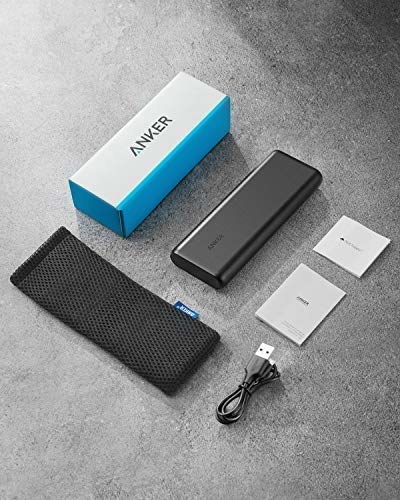 An Anker power bank set with a power bank, mesh carrying case, USB cable, user manual, and box displayed on a flat surface