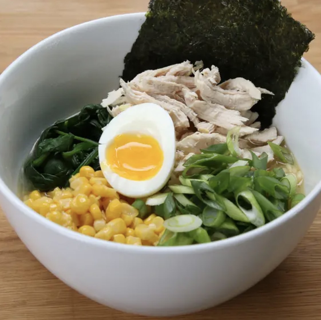 Bowl of ramen with chicken, corn, seaweed, egg 