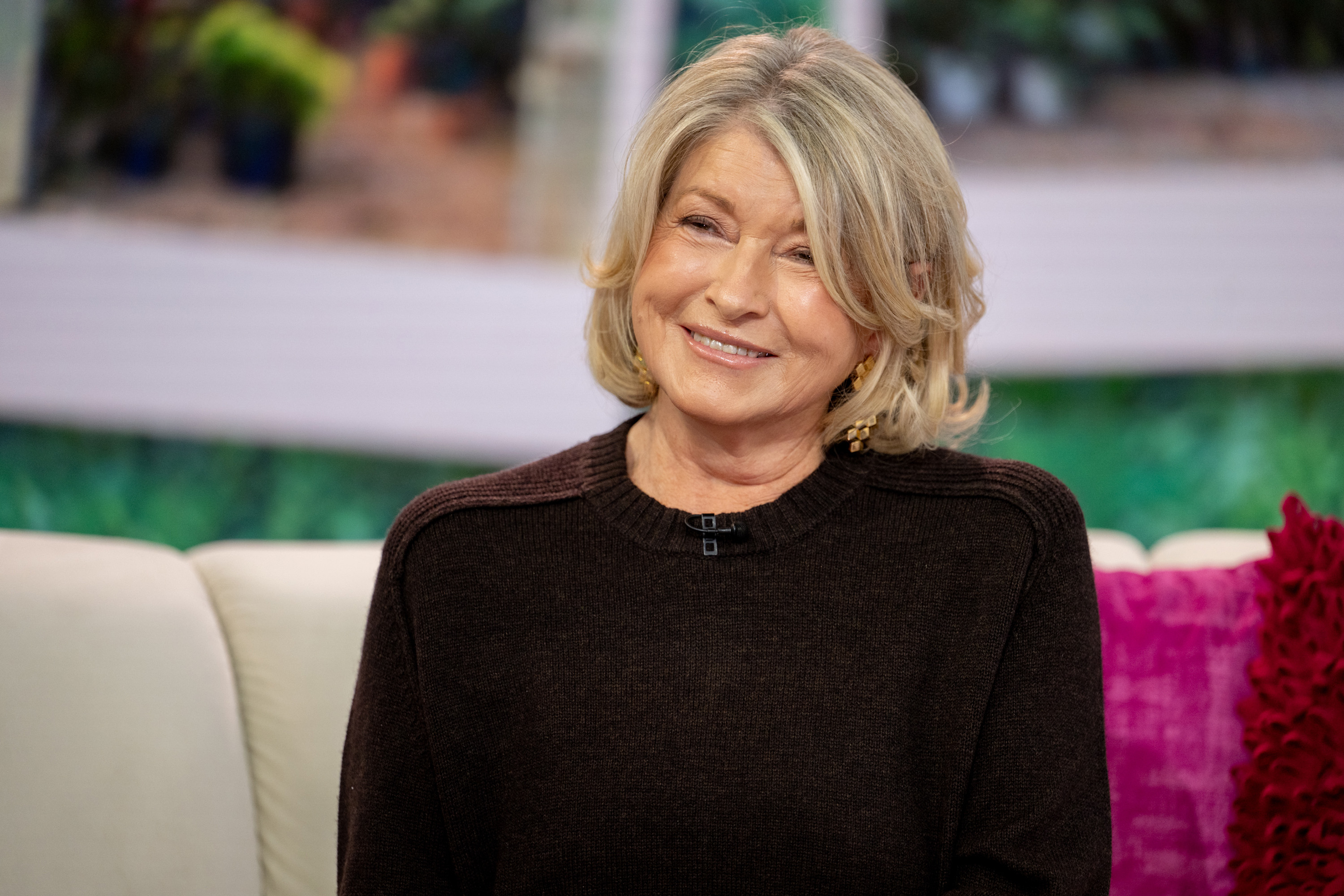 Martha sitting and smiling on a couch during a TV show appearance