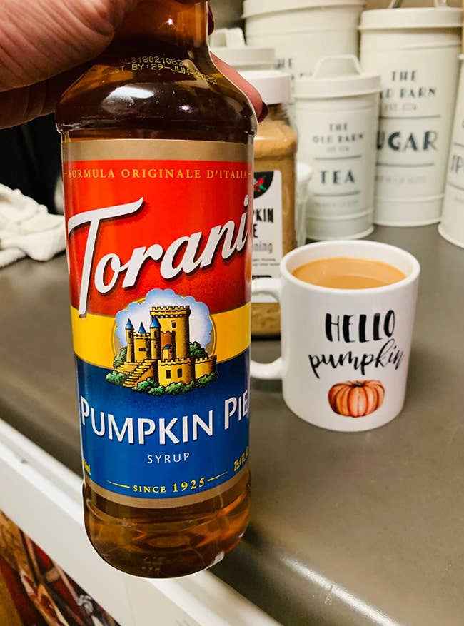 reviewer image of bottle of pumpkin pie syrup and a coffee cup with coffee in it