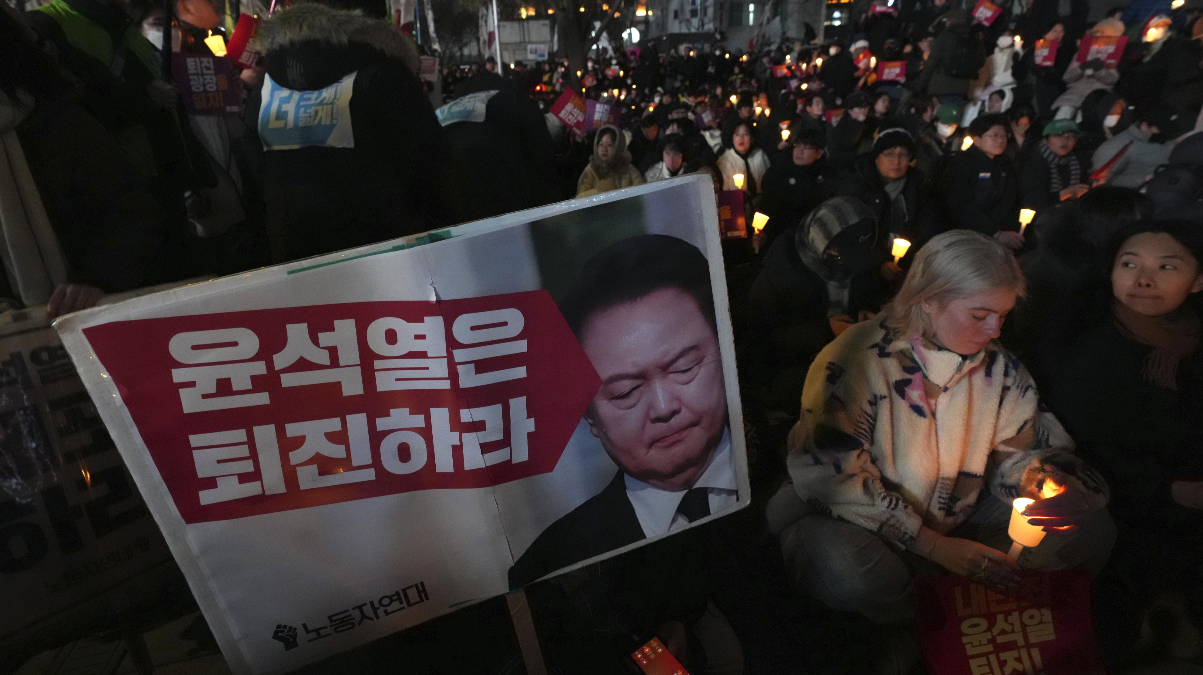 4日、韓国の尹錫悦大統領の辞任を求め、ろうそくをともす人々＝ソウル（AP＝共同）