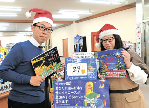 クリスマスにお薦めの本を持ち、「ブックサンタ」をＰＲする書店員＝高松市朝日新町、宮脇書店総本店