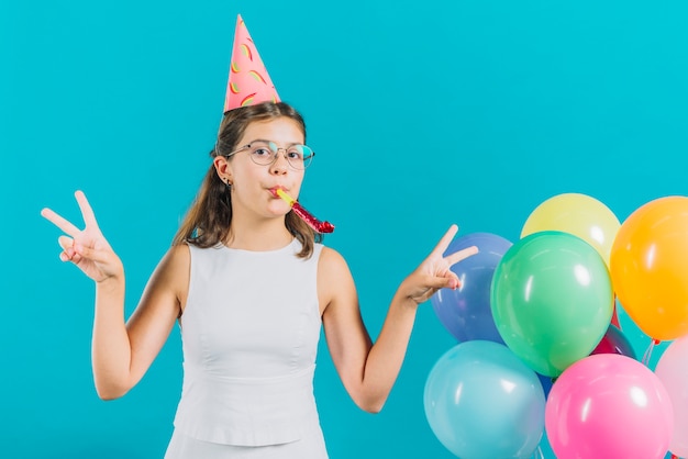 Free Photo | Girl gesturing peace sign near colorful balloons on ...