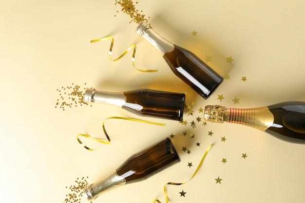 Premium Photo | Champagne bottles and glitter on beige. Holiday concept