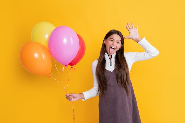 Premium Photo | Cheerful child with party helium balloons on yellow ...