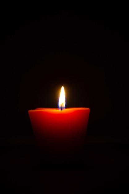 Premium Photo | Closeup of burning candle isolated on black background.