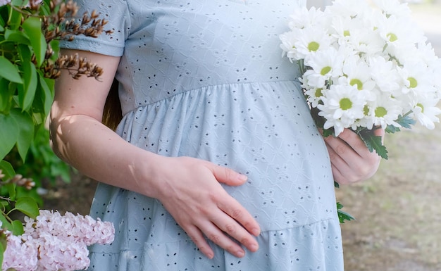 Premium Photo | Closeup of a pregnant girl in a soft blue dress with a ...