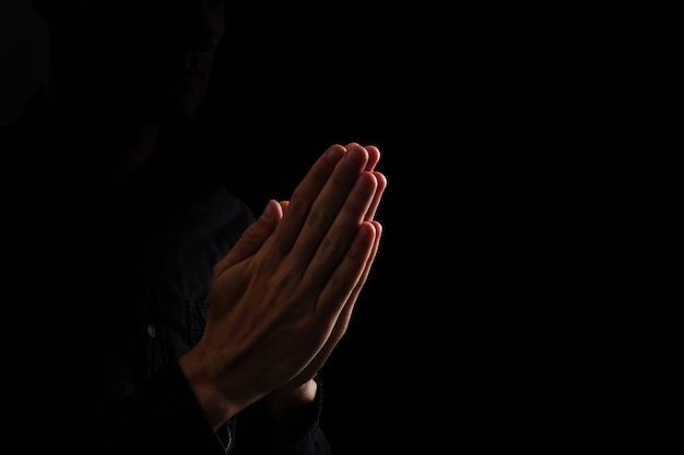 Premium Photo | Image of praying hands on a black background