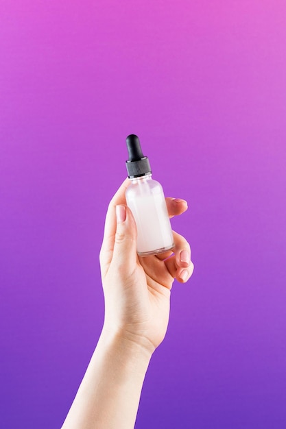 A mockup of a glass dropper with skin oil in a woman39s\
hand