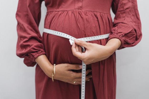 Premium Photo | Muslim pregnant woman measuring her belly stomach