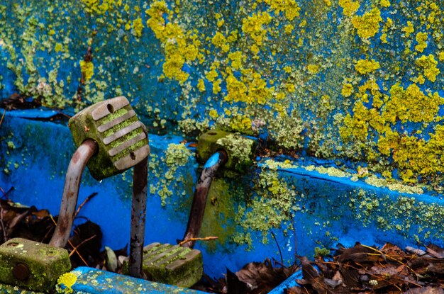 Old boats and catamarans are rusting in the open dump in the\
forest at the foot of the river bank of outdated water equipment\
pedals and moss close up environmental pollution