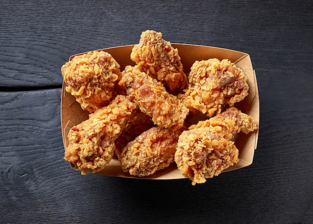 Premium Photo | Paper Take Away Box Of Fried Chicken Wings On Black Wood  Background, Top View