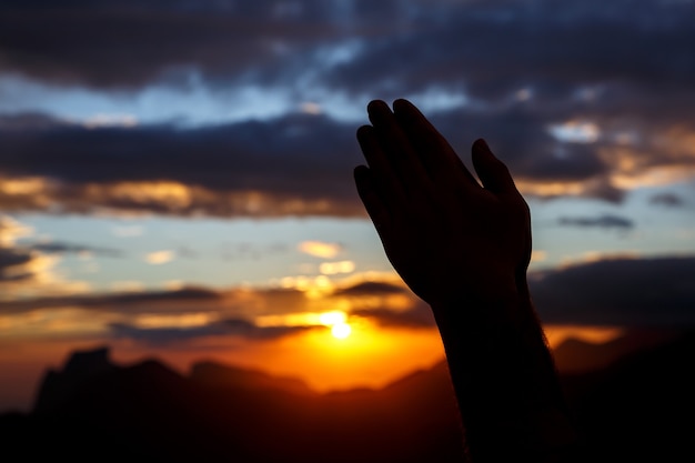 Premium Photo | Praying hands on sunset background. black silhouette