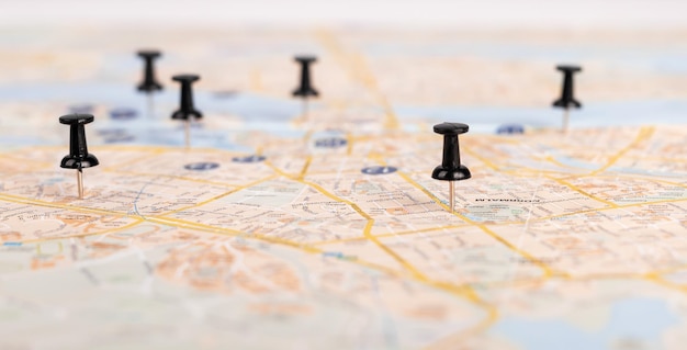 Push pins on paper map road travel concept planning\
itinerary