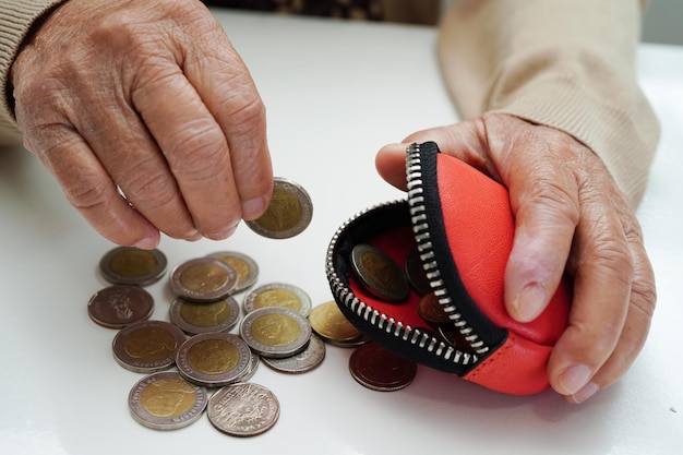 Premium Photo | Retired elderly woman counting coins money and worry ...