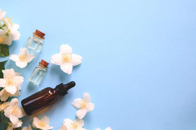 Tender jasmine flowers and oil small bottle with cosmetic\
cleansing aroma oil and white jasmine flowers natural skin care\
homemade spa and beauty treatment recipe copy space