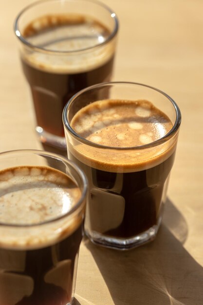 Premium Photo | Three espresso coffees in glass cups on a wooden table ...