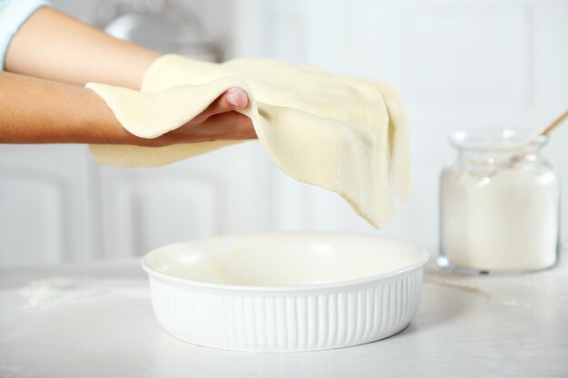 Premium Photo | Woman making pie on wooden table on light background