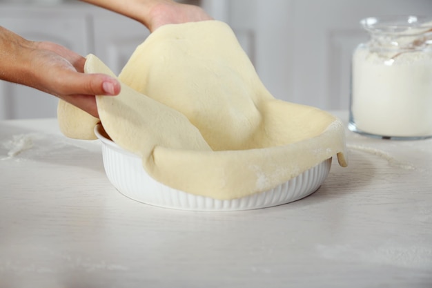 Premium Photo | Woman making pie on wooden table on light background