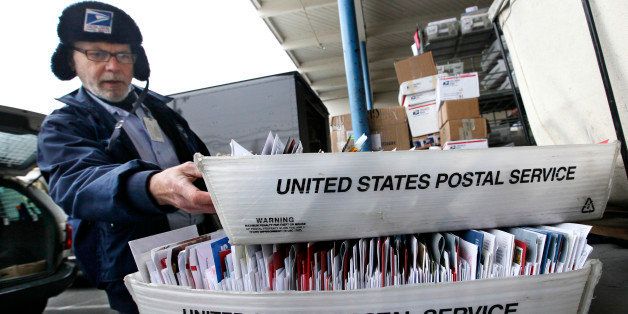 Letter carrier Sean Bailey moves boxes of mail to his van to begin delivery Monday, Dec. 5, 2011, at a post office in Seattle. The cash-strapped U.S. Postal Service said Monday it is seeking to move quickly to close 252 mail processing centers and slow first-class delivery next spring, citing steadily declining mail volume. The cuts are part of $3 billion in reductions aimed at helping the agency avert bankruptcy next year. The plant closures are expected to result in the elimination of roughly 28,000 jobs nationwide. (AP Photo/Elaine Thompson)