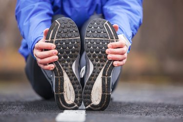 Cropped shot of a young runner stretching after workout.