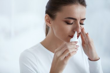 Beautiful Woman Using Nasal Spray for a sinus infection