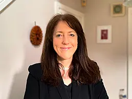 A woman in a black patterned shirt smiling at the camera. She is Róisín Wallace of Viatris Ireland.