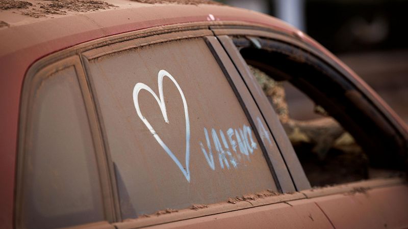 Un coraz�n pintado en un coche cubierto de polv en Paiporta