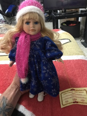 Value of a Collector's Choice Doll - doll wearing a pink and white knit hat and scarf with a dark blue dress with snowflakes