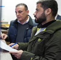 Semir von Lewinski (l), Mitarbeiter der Landesaufnahmebehörde Niedersachsen, steht während der Ausgabe der Bezahlkarte an Mohammad (r), Geflüchteter aus Syrien, hinter einem Tresen. Daneben steht ein Dolmetscher (2.v.l). Der Bund hat mit der Änderung des Asylbewerberleistungsgesetzes die Möglichkeit eröffnet, dass auch Geflüchtete mit einer Bezahlkarte ohne Bargeld zahlen können. Zunächst sollen die etwa 4.100 Bewohner der Landaufnahmebehörde mit den Karten versorgt werden. Die Ausgabe in den Kommunen für etwa 28.000 Berechtigte ist ab Februar 2025 vorgesehen. +++ dpa-Bildfunk +++