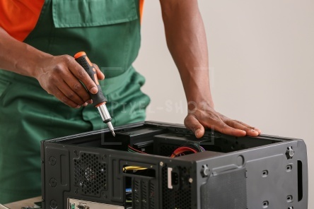 African-American technician repairing computer in service center, closeup