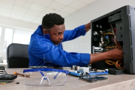 African-American technician repairing computer in service center